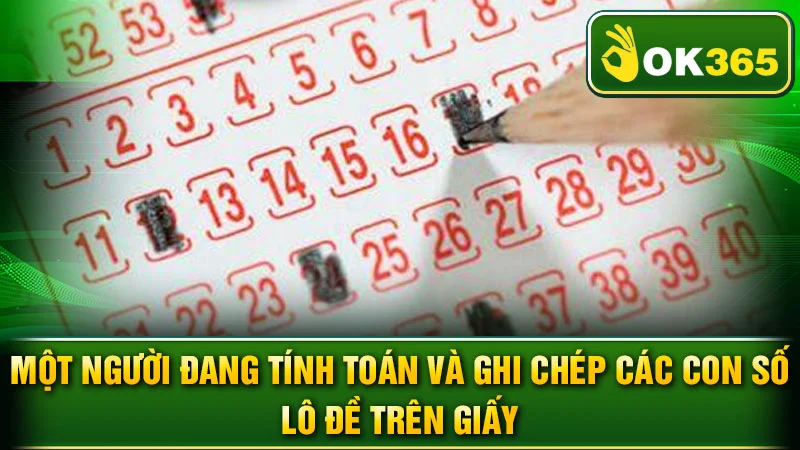 Một người đang tính toán và ghi chép các con số lô đề trên giấy.